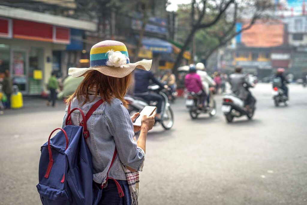 Reiziger in Vietnam die met mobiele data op haar smartphone navigeert in een drukke straat