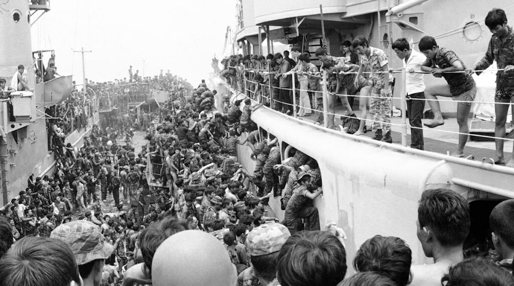 Boten halen Zuid Vietnamese soldaten op na de val van Saigon aan het einde van de VIetnamoorlog