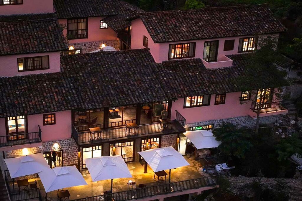 Ha Giang Aya Lodge in de avond met warme verlichting en traditionele dakpannen.
