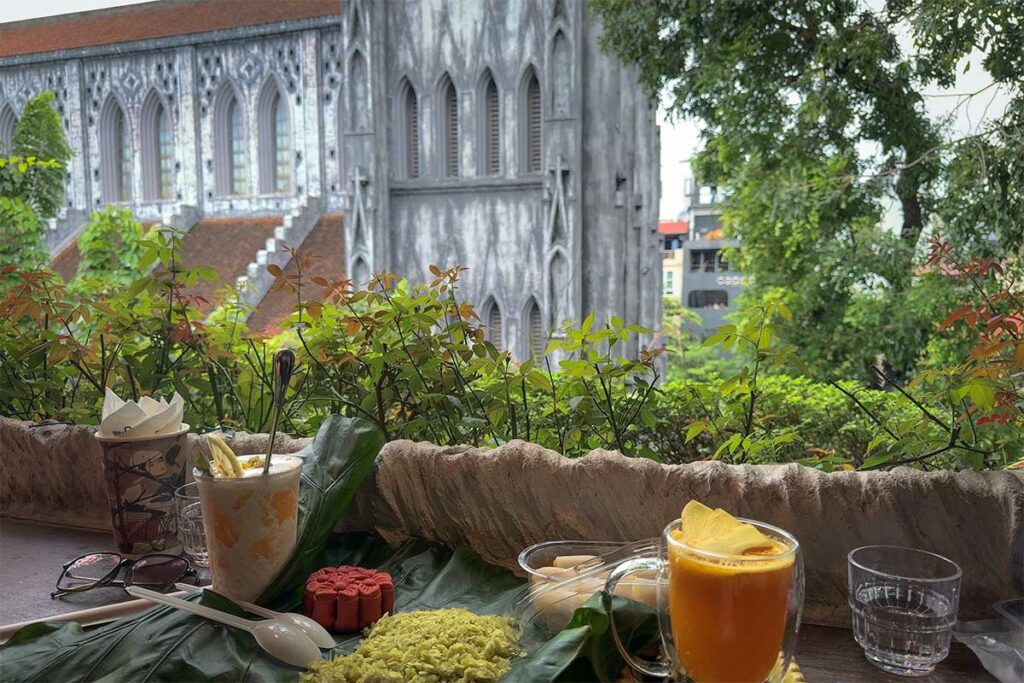 Drankjes op tafel met uitzicht op de zijgevel van St. Joseph’s Cathedral in Hanoi vanuit 9981 Coffee – Wine – Tapas