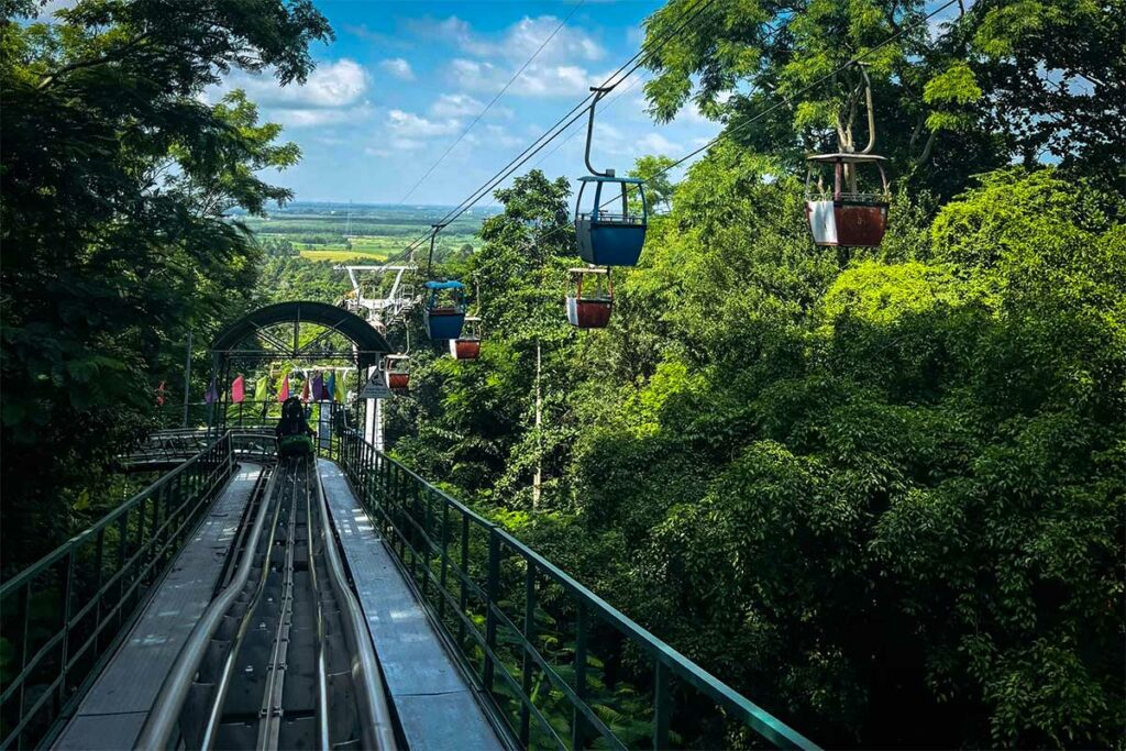 Alpine coaster op Ba Den Mountain, een rodelbaan door het bos met kabelbaan op de achtergrond