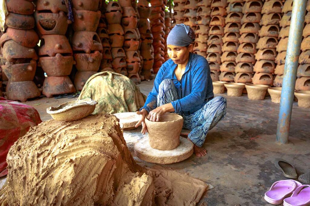Lokale pottenbakker werkt met klei aan een handgemaakte pot in Bat Trang Ceramic Village bij Hanoi