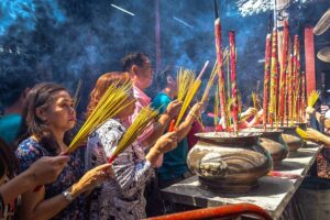 Lokale bezoekers die wierook branden in een Chinese tempel in Chinatown Ho Chi Minh City, een belangrijk religieus ritueel in Cho Lon.