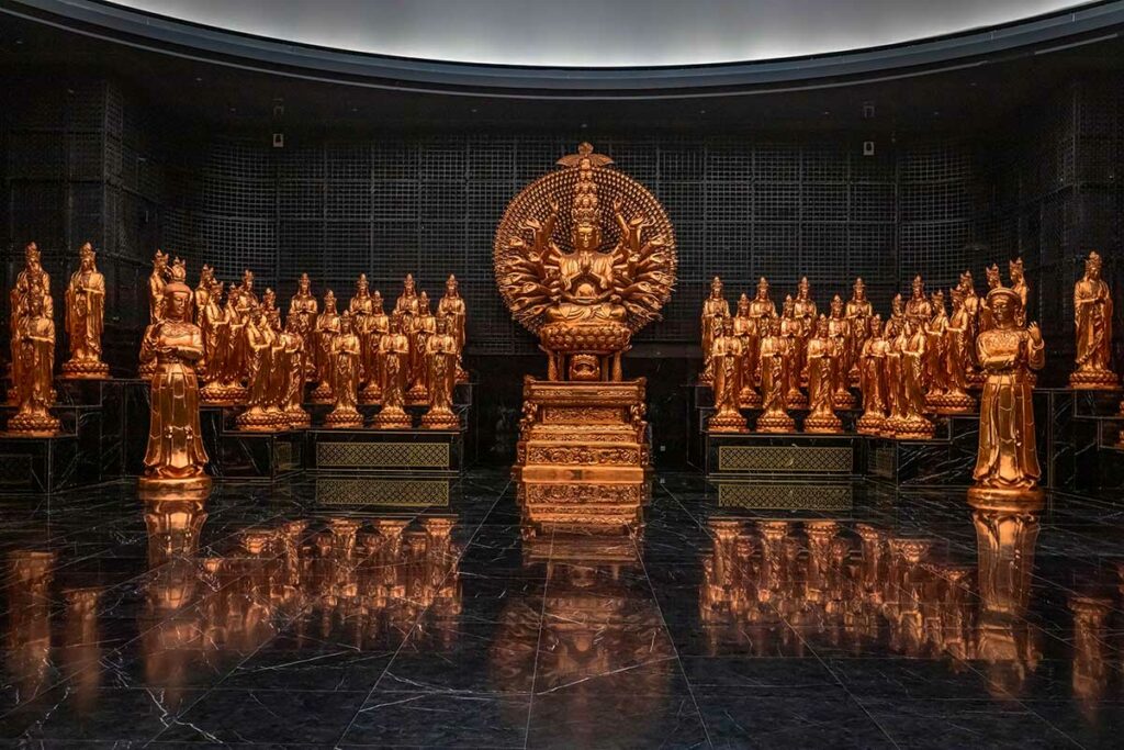 Binnenruimte met vergulde boeddhistische beelden bij het Bodhisattva-heiligdom op Ba Den Mountain
