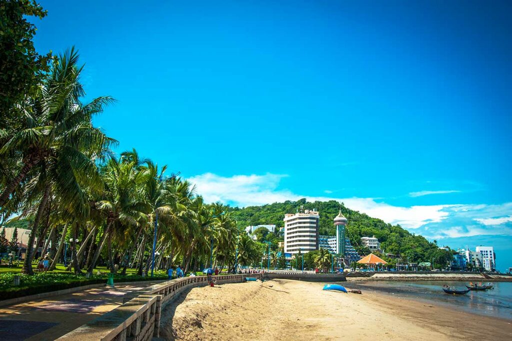 Front Beach in Vung Tau met palmbomen, boulevard en uitzicht op de stad en heuvels op de achtergrond