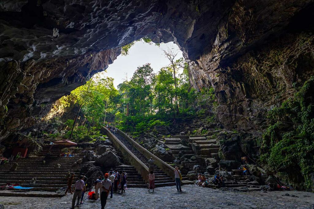 Binnenkant van de Huong Tich-grot bij de Perfume Pagoda, met trappen, rotsformaties en bezoekers in de heilige grot