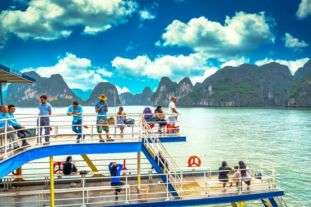 Uitzicht vanaf de veerboot tussen Hai Phong en Cat Ba met karstbergen en passagiers aan dek