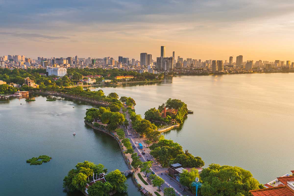 Panoramisch uitzicht over Hanoi bij helder weer, met West Lake en de skyline in zacht avondlicht