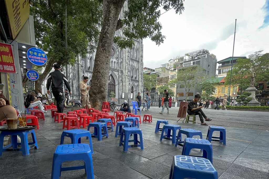 Straatstoeltjes bij Hiếu Coffee met zicht op St. Joseph’s Cathedral en het plein in Hanoi