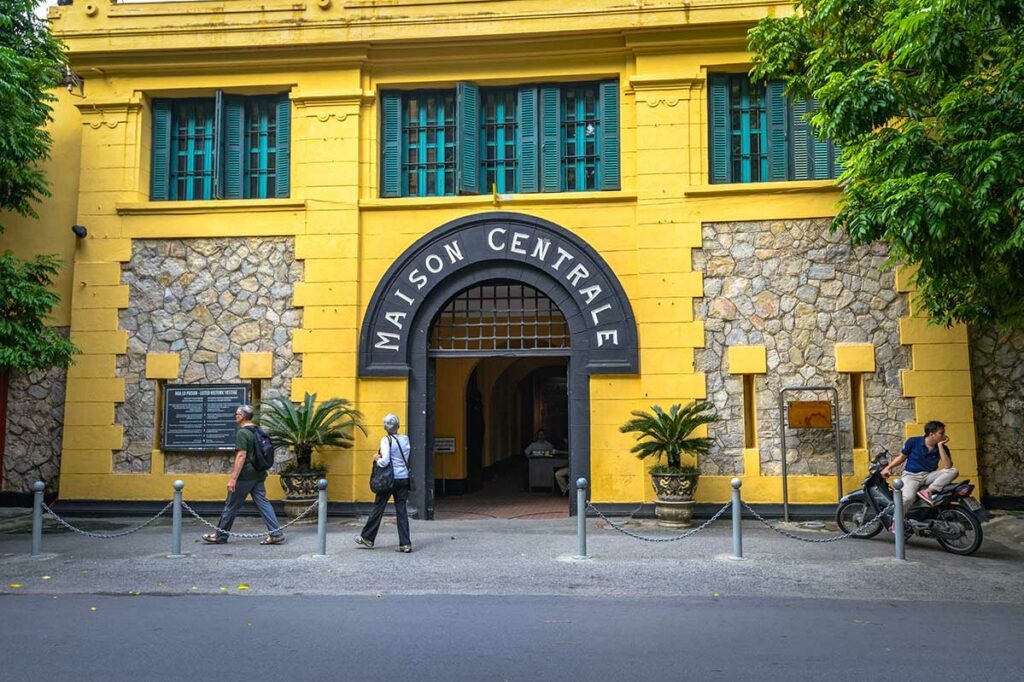 Voorkant van Hoa Lo Prison in Hanoi, ook bekend als de Hanoi Hilton, met bezoekers bij de ingang