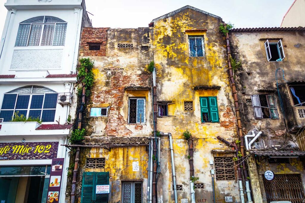Oude, verweerde huizen in het Old Quarter van Hai Phong met Franse koloniale invloeden en kleurrijke luiken