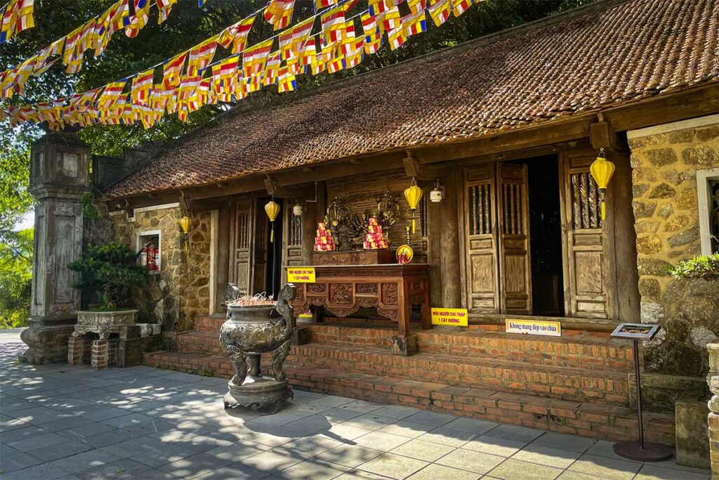 Huong Tich-pagode bij Vinh, een boeddhistische tempel met traditionele architectuur, vlaggen en een rustige binnenplaats.