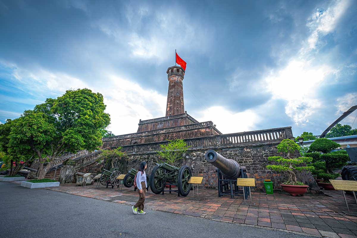 Historische kanonnen rond de voet van de Hanoi Flag Tower, met zicht op de massieve stenen fundering