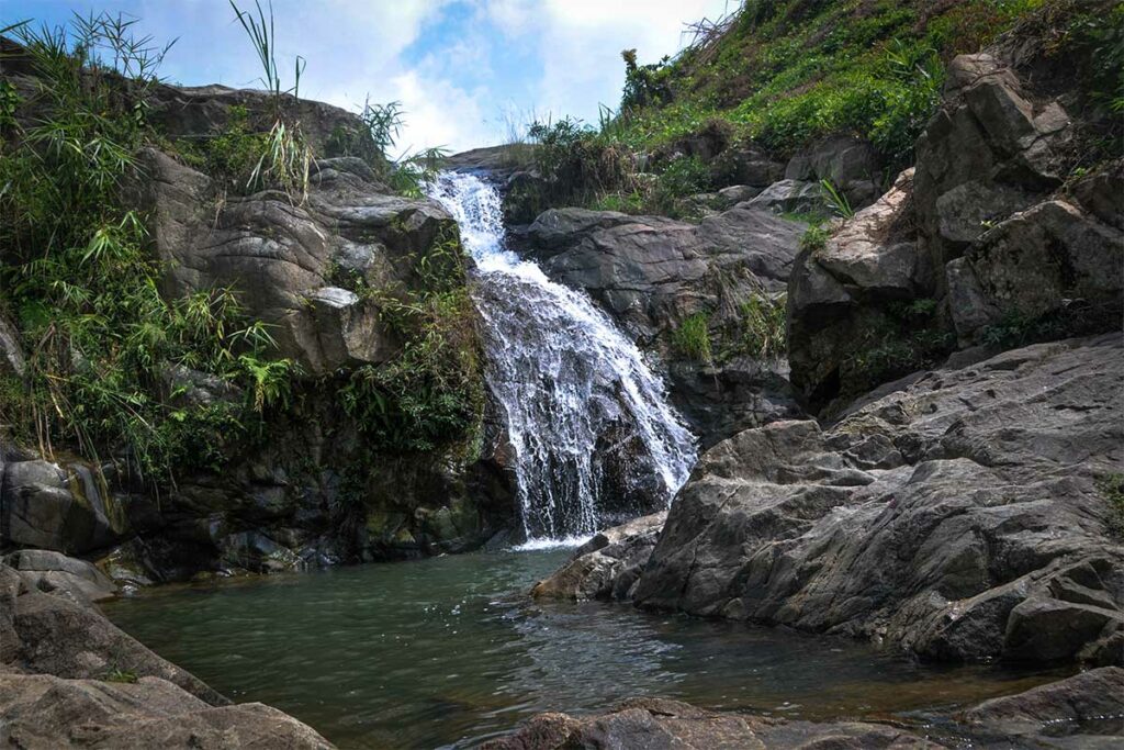 Kleine Khuon Tat-waterval in Thai Nguyen met rotsen en een natuurlijke poel in een bosrijke omgeving