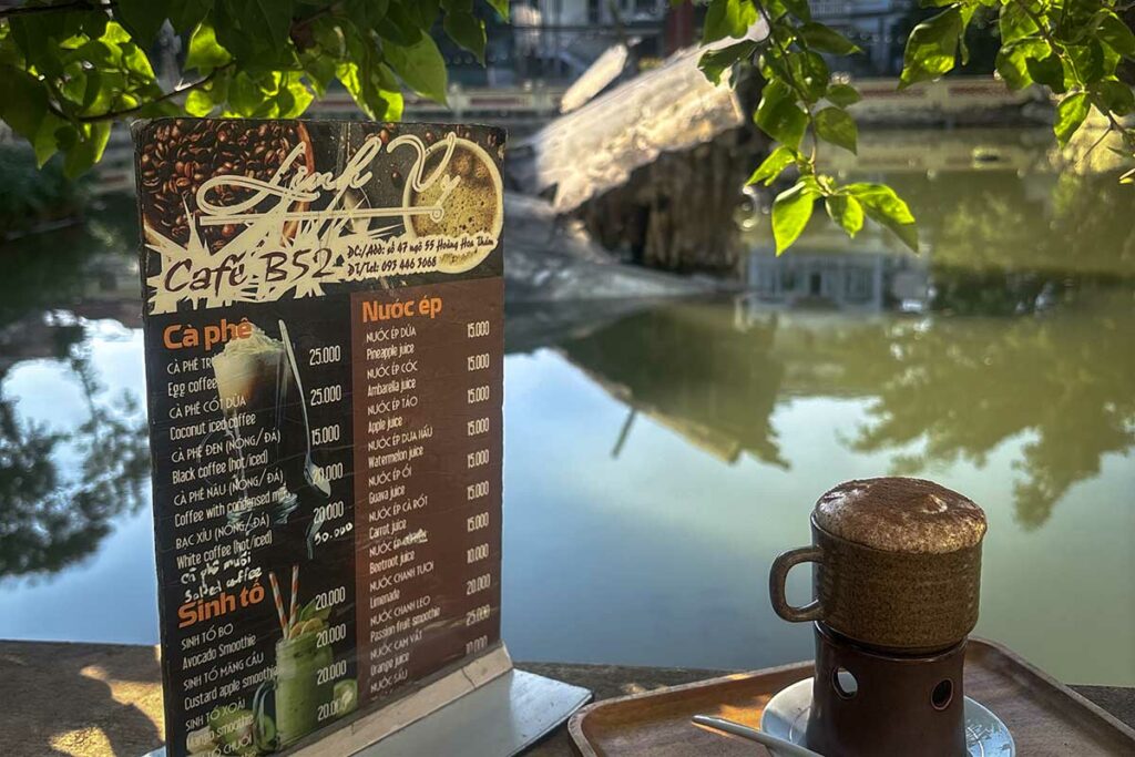Vietnamese koffie aan de waterkant bij B-52 Lake (Huu Tiep Lake) in Hanoi, met uitzicht op het meer en het vliegtuigwrak
