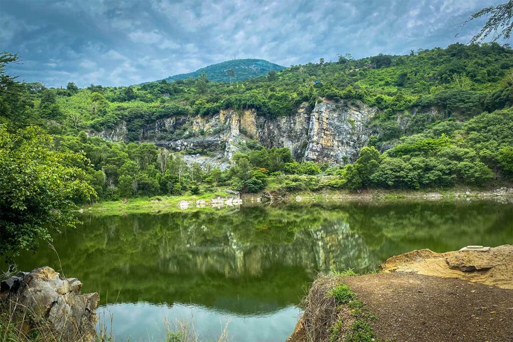 Meer in de Ma Thien Lanh-vallei bij Tay Ninh, met rotsen en beboste heuvels op de achtergrond
