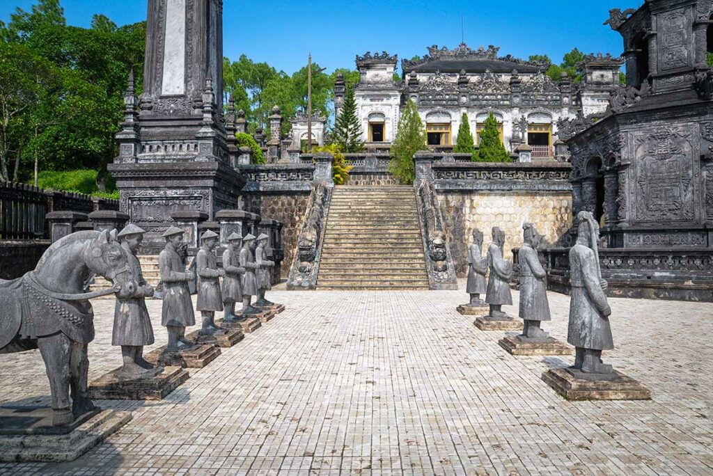 Stenen beelden van mandarijnen en soldaten in het eerhof van de Tombe van Khai Dinh in Hue, opgesteld langs de centrale as van het complex.