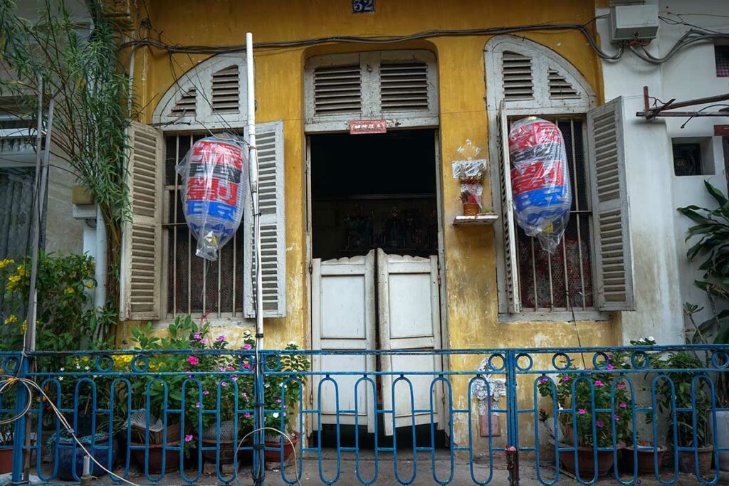 Portiek van een traditioneel appartementencomplex in Hao Si Phuong Alley, Chinatown Ho Chi Minh City, met gedeelde gangen en eenvoudige woonruimtes.