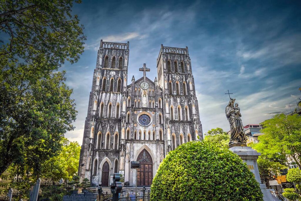 St. Joseph’s Cathedral in Hanoi gezien vanaf het plein met de twee neogotische torens en Mariabeeld op de voorgrond