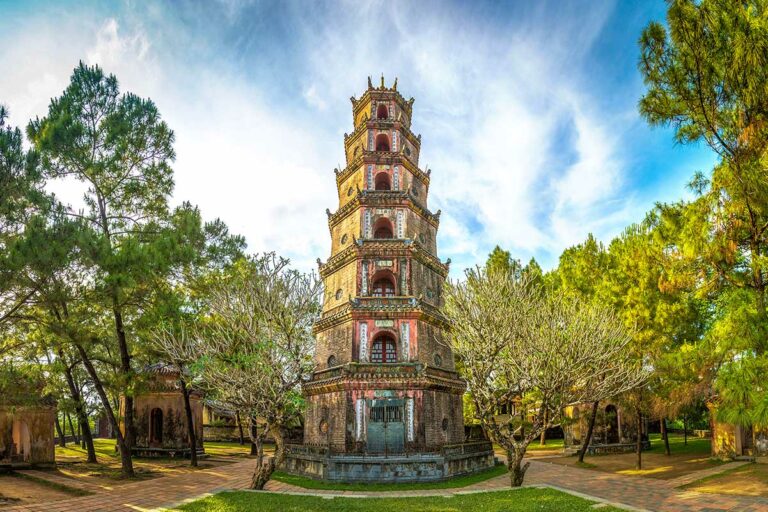 De Phuoc Duyen-toren van Thien Mu Pagoda in Hue, een zeven verdiepingen hoge stoepa omringd door bomen binnen het tempelcomplex.