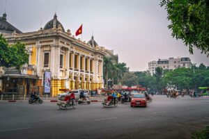 Straatbeeld in de Franse wijk (French Quarter) van Hanoi met het Hanoi Opera House en verkeer op de voorgrond