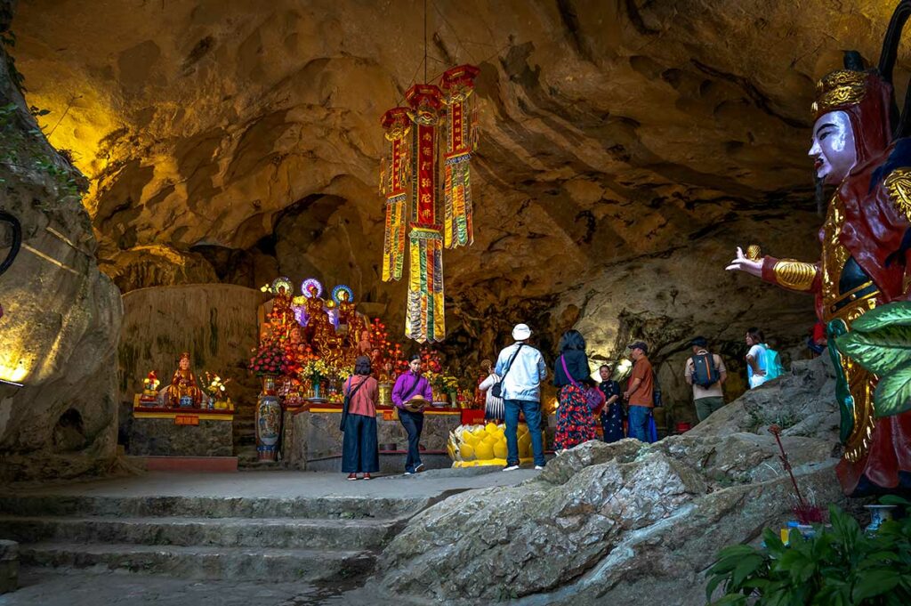 Tam Thanh Pagoda in een kalkstenen grot in Lang Son, waar bezoekers bidden tussen rotsformaties en boeddhistische beelden