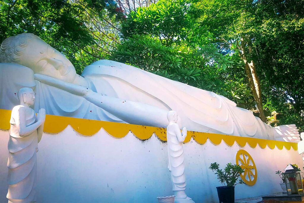 Liggende Boeddha bij de Thich Ca Phat Dai-pagode in Vung Tau, omgeven door groen
