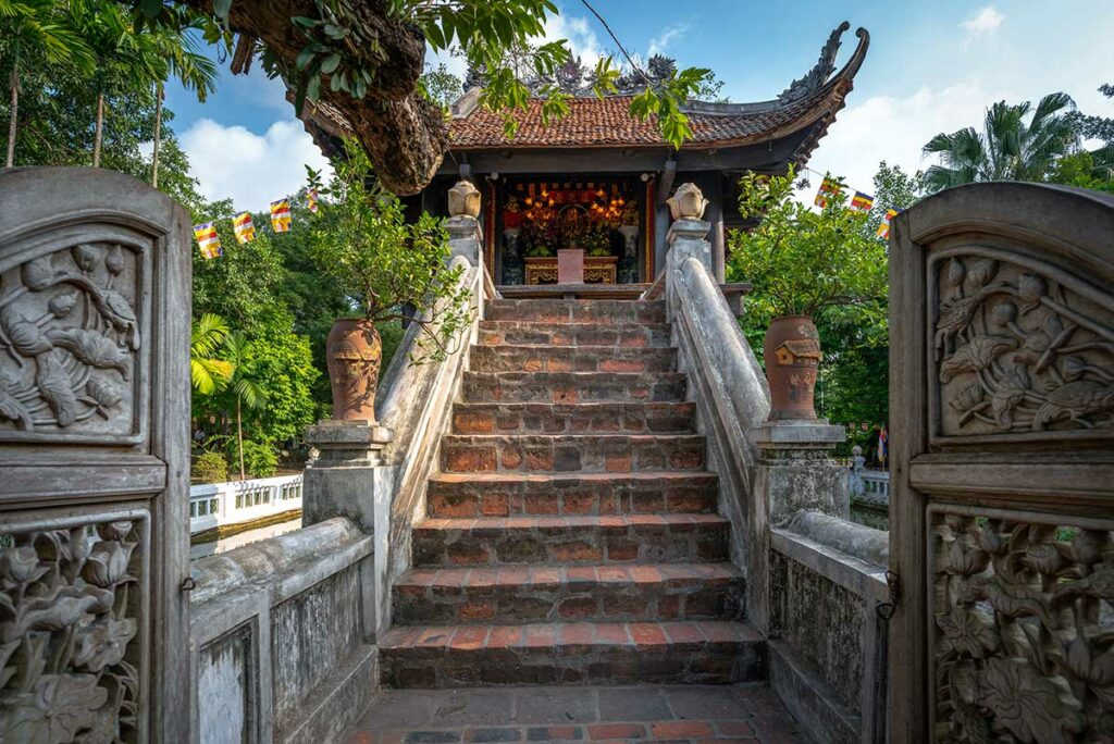 Vooraanzicht van de One Pillar Pagoda in Hanoi, gezien vanaf de stenen trap met traditionele reliëfs en het altaar zichtbaar in de tempel