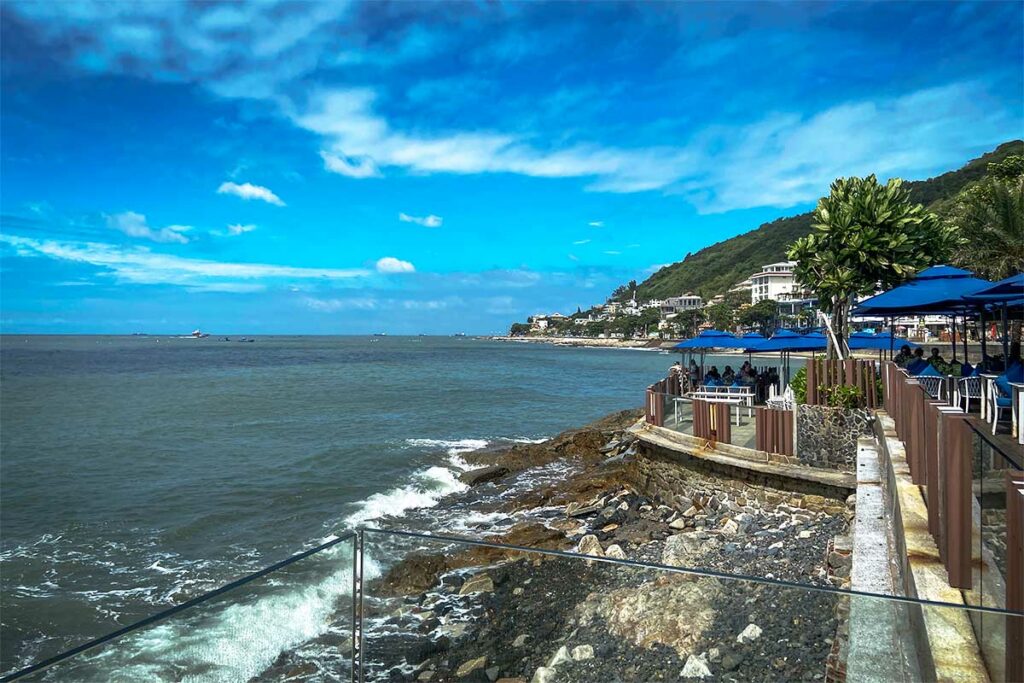 itzicht over zee vanaf het terras van Marina Club Vung Tau langs de rotsachtige kustlijn