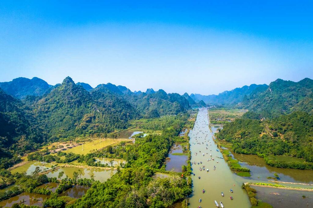 Booten op de Yen Stream bij de Perfume Pagoda, omringd door groene heuvels en karstbergen ten zuiden van Hanoi