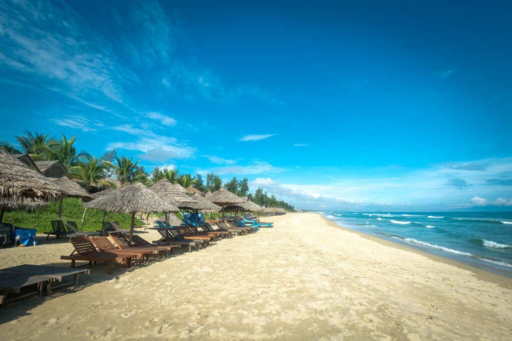 Lange zandstrook van An Bang Beach in Hoi An met ligbedden en zee op de achtergrond