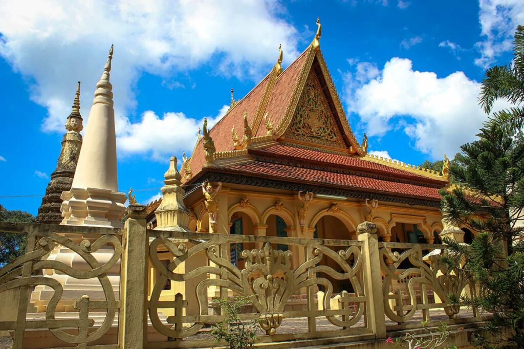 Voorzijde van Ang Pagoda in Tra Vinh met zuilen, kleurrijk dak en traditionele Khmer-details