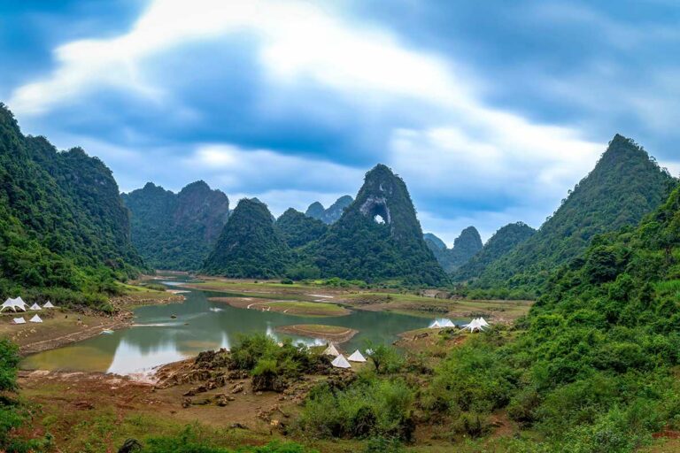 Angel Eye Mountain in Cao Bang gezien vanaf de vallei, met het natuurlijke gat duidelijk zichtbaar tussen de groene karstbergen.
