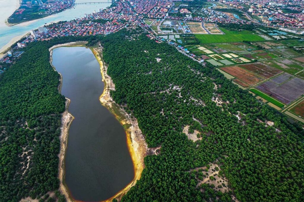 Luchtfoto van Bau Tro Lake bij Dong Hoi, een zoetwatermeer omringd door groen en landbouwgrond aan de rand van de stad.