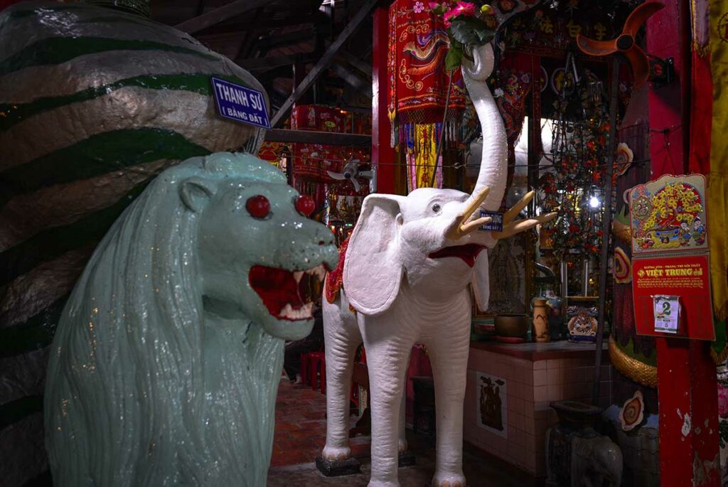 Kleibeelden van olifant en leeuw in Clay Pagoda Chua Dat Set in Soc Trang met kleurrijke tempeldecoraties op de achtergrond