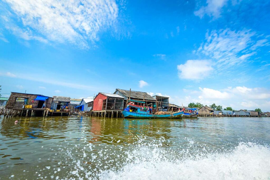 Huizen op palen langs rivier in Ca Mau vissersdorp in de Mekong Delta Vietnam