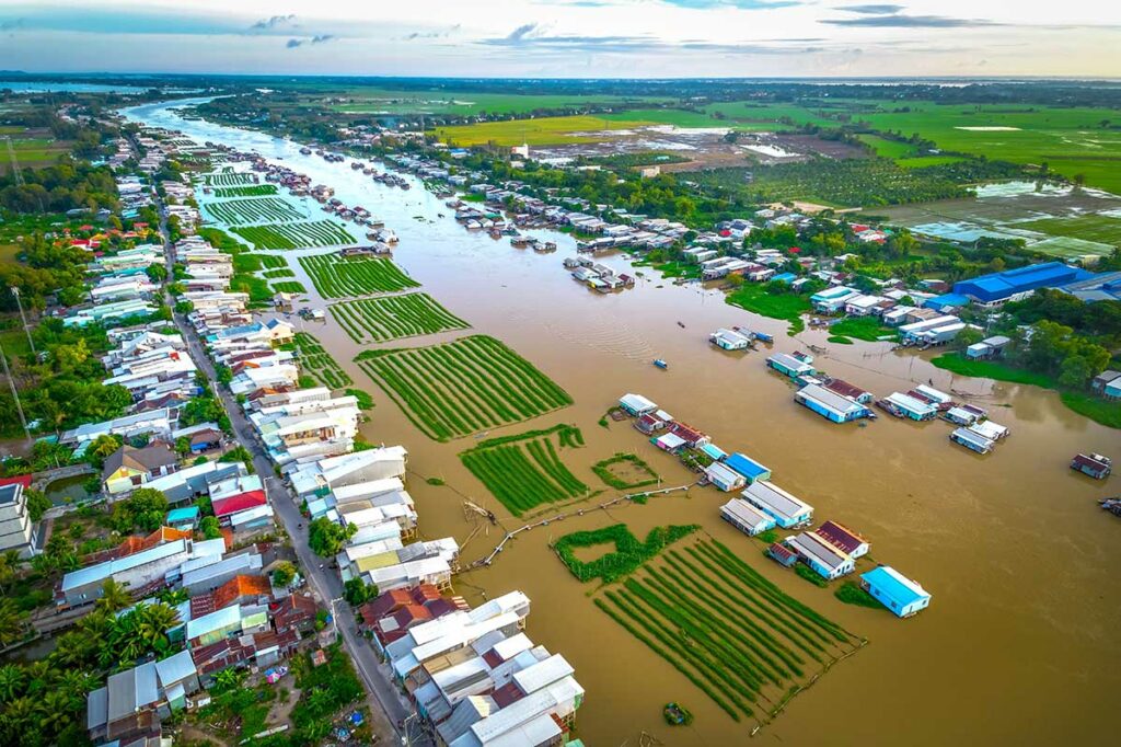 Luchtfoto van drijvend dorp bij Chau Doc met huizen en groenteteelt op het water in de Mekongdelta