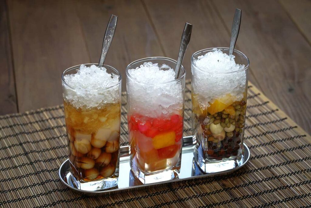 Glazen met chè, een Vietnamees dessert met bonen, fruit, jelly en ijs, vaak gegeten als zoet tussendoortje in Vietnam