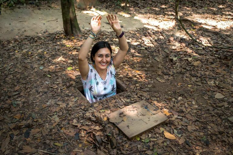 Bezoeker kruipt uit een verborgen tunnelopening bij de Cu Chi Tunnels, gebruikt door Viet Cong-strijders tijdens de Vietnamoorlog