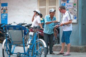 Toerist onderhandelt over de prijs van een cyclo riskja rit in een Vietnamese stad