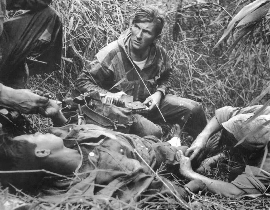 Franse legerarts verleent eerste hulp aan een gewonde Vietnamese parachutist tijdens de Slag bij Dien Bien Phu