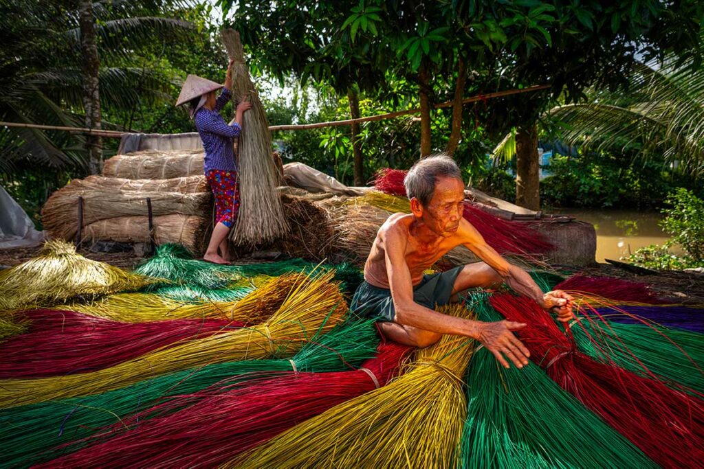 Lokale bewoners bundelen en verven biezen voor handgeweven matten in Dinh Yen weefdorp nabij Sa Dec