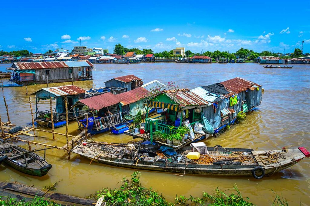 Drijvend dorp in Chau Doc op de Hau rivier met houten huizen en vissersboten in de Mekongdelta