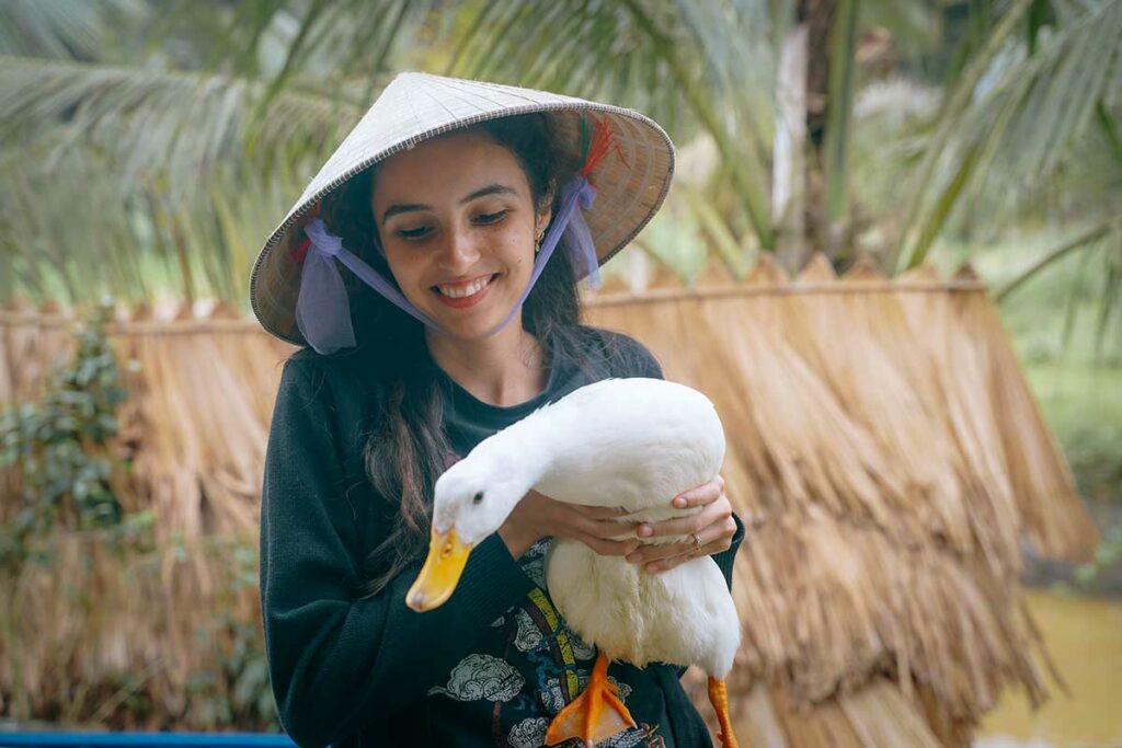 Bezoeker houdt een eend vast bij The Duck Stop in Phong Nha, een speelse en interactieve boerderijactiviteit.