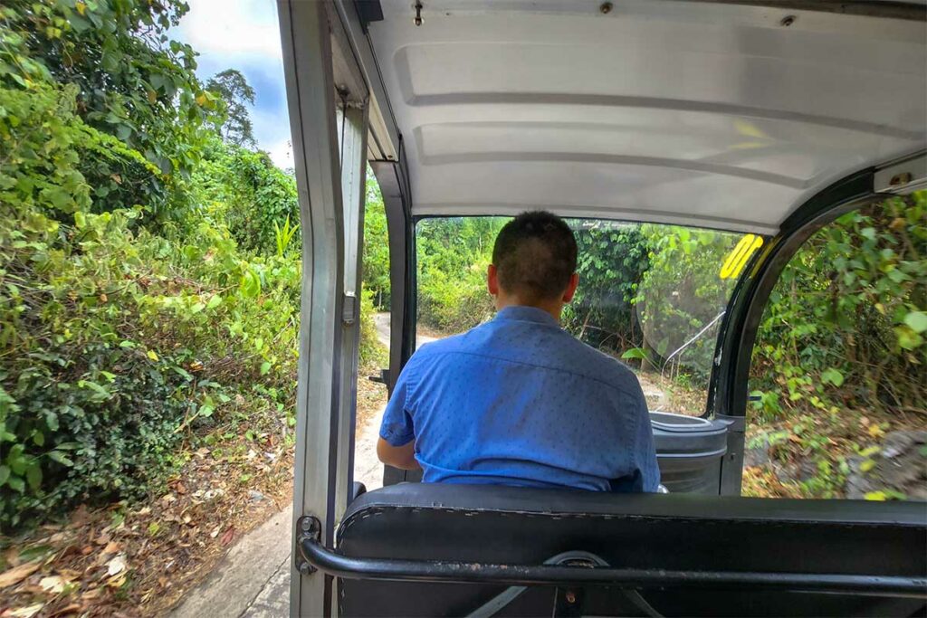 Elektrische golfkar die bezoekers vanaf de parkeerplaats door de jungle naar de ingang van Paradise Cave in Phong Nha brengt.