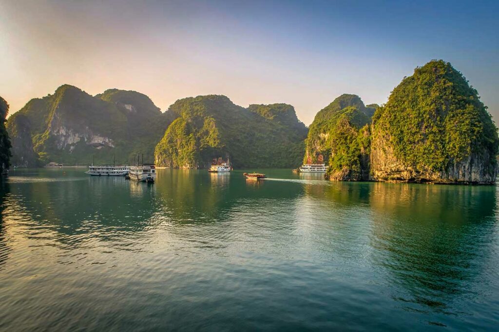 Overzicht van Halong Bay met kalkstenen eilanden en cruiseschepen in rustig water, een iconische locatie voor landschapsfotografie in Vietnam.