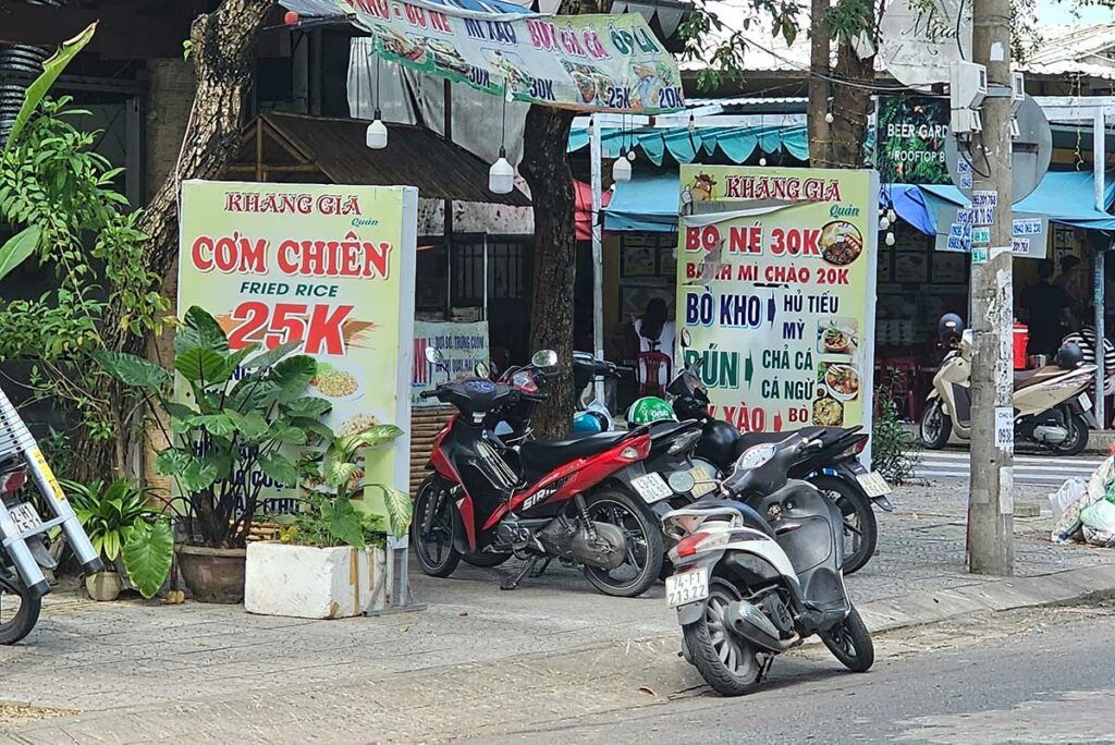 Straatborden met lage prijzen voor rijst- en noedelgerechten, wat laat zien hoe betaalbaar street food in Vietnam is