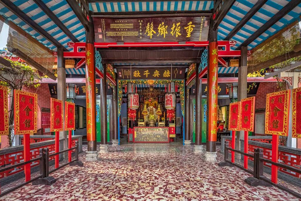 Altaar in Hai Nam Assembly Hall in Hoi An met rood-gouden decoratie en Chinese inscripties
