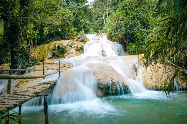 Hieu Waterfall in Pu Luong Nature Reserve met meerdere terrassen, houten loopbruggen en helder blauwgroen water in de jungle