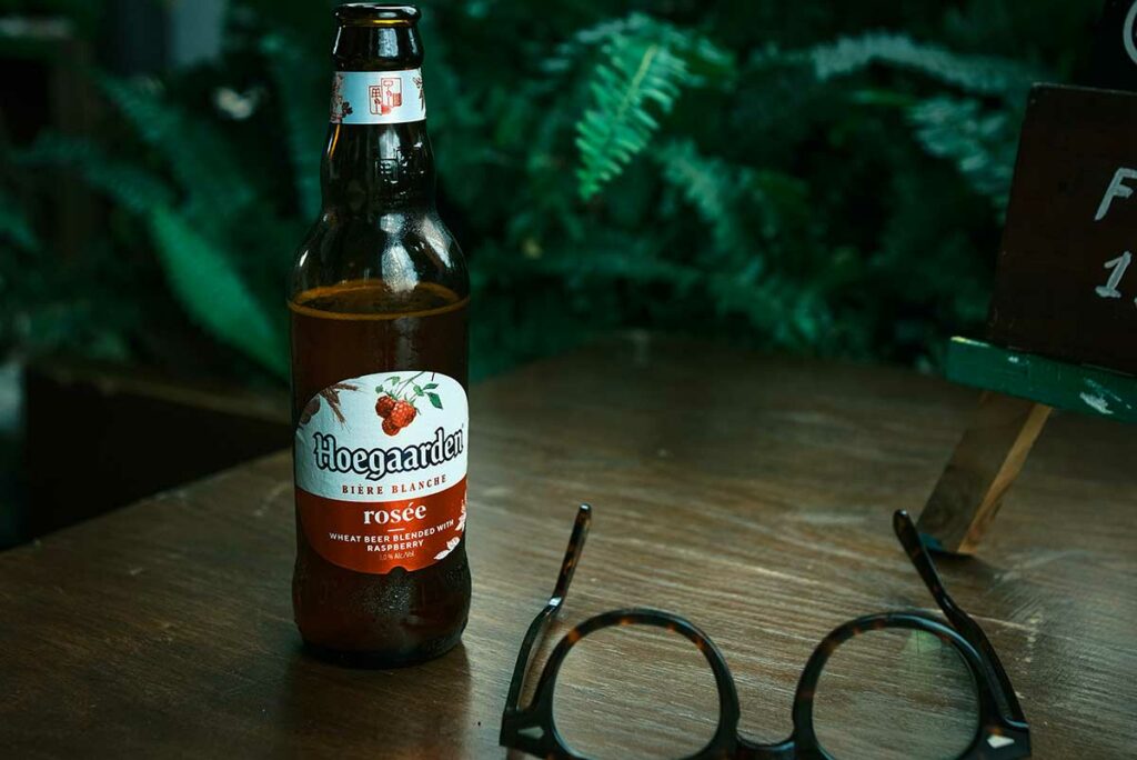 Fles Hoegaarden Rosée bier op een tafel in Vietnam, een geïmporteerd Belgisch bier dat vooral in cafés en speciaalbierbars wordt gedronken